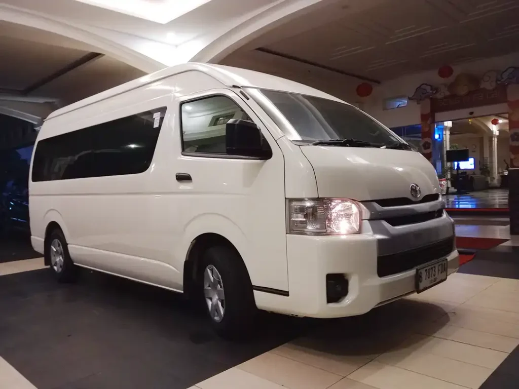 Toyota Hiace is parked in front of a hotel lobby in Jogjakarta city to pick up the tourist for a Timang Beach Tour.